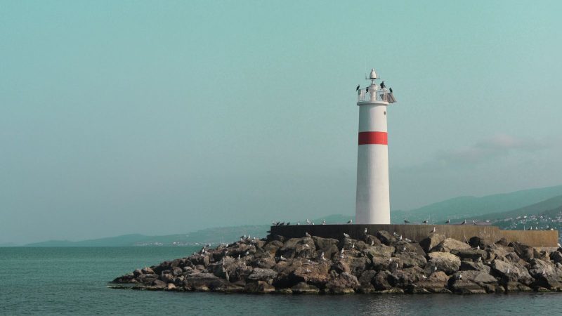 Lighthouse on a rocky breakwater, wide shot